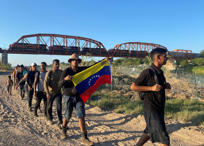 Jesus Ramirez, 29, with a Venezuelan flag, crosses into the U.S. from Mexico with hundreds of Venezuelans in Eagle Pass, Texas, early on September 23, 2023. Thousands of migrants arrived at the U.S.-Mexico border September 22, hoping to be allowed into the United States, with U.S. border forces reporting 1.8 million encounters with migrants in the last 12 months. 