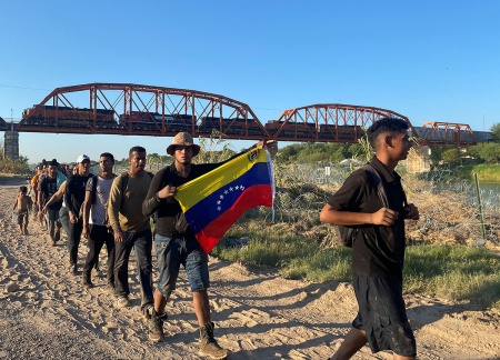 Jesus Ramirez, 29, with a Venezuelan flag, crosses into the U.S. from Mexico with hundreds of Venezuelans in Eagle Pass, Texas, early on September 23, 2023. Thousands of migrants arrived at the U.S.-Mexico border September 22, hoping to be allowed into the United States, with U.S. border forces reporting 1.8 million encounters with migrants in the last 12 months.