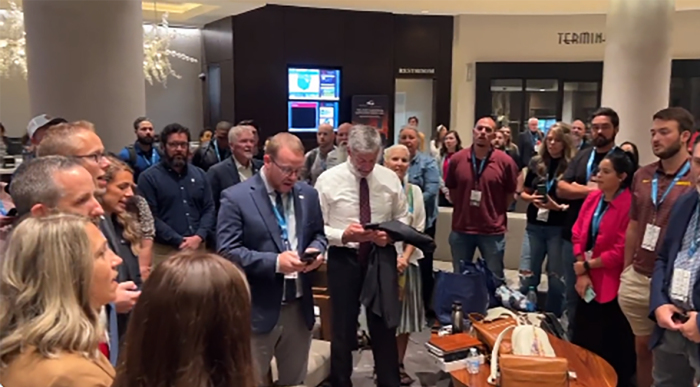 Attendees of the G3 Conference break out in song in a Marriott lobby after a bomb threat forced them to evacuate the Georgia International Conference Center where the event was taking place, on September 22, 2023. 
