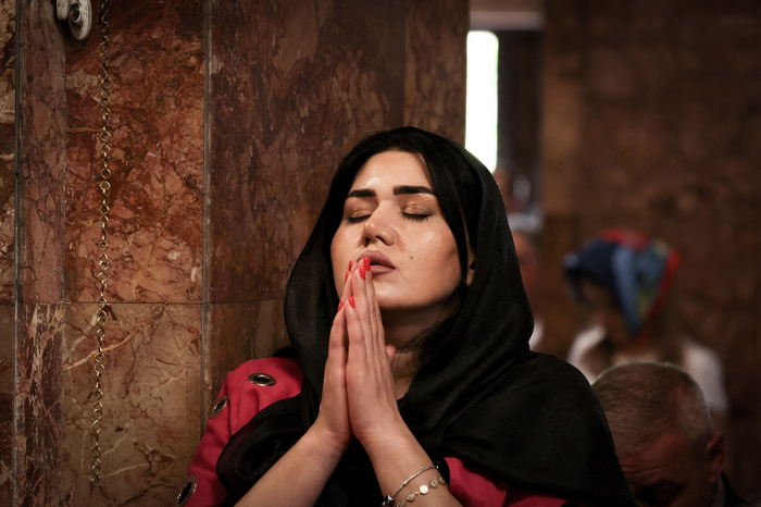 A woman prays during a service for the Nagorno-Karabakh refugees at the Saint-Sargis vicarial church as part of the nationwide prayer for Artsakh day in Yerevan, the capital of Armenia, on October 1, 2023. 