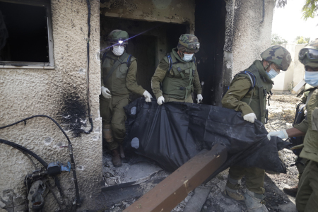 Israeli soldiers remove the body of a civilian, who was killed days earlier in an attack by Palestinian militants on this kibbutz near the border with Gaza, on October 10, 2023, in Kfar Aza, Israel. Israel has sealed off Gaza and conducted airstrikes on Palestinian territory after Hamas' attack killed hundreds and took 230 hostages. On October 7, the Palestinian militant group Hamas launched a surprise attack on Israel from Gaza by land, sea and air, killing over 1,400 people and wounding more than 3,000. Israeli soldiers and civilians have also been taken hostage by Hamas and moved into Gaza. The attack prompted a declaration of war by Israeli Prime Minister Benjamin Netanyahu, and ongoing retaliatory strikes by Israel on Gaza killing hundreds.