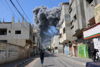 Smoke billows behind buildings after after an Israeli air strike in Rafah in the southern Gaza Strip on October 11, 2023.  