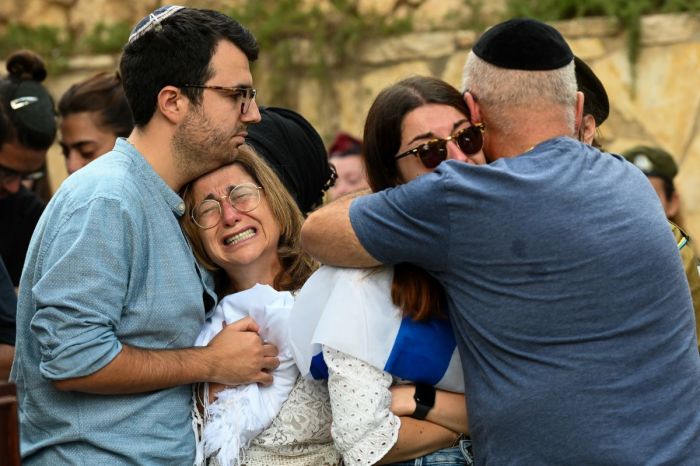 The mother, and immediate family of Valentin (Eli) Ghnassia, 23, who was killed in a battle with Hamas militants at kibbutz Be’eeri near the Israeli border with the Gaza Strip, grieve during his funeral on October 12, 2023 at Mount Herzl Military Cemetery in Jerusalem, Israel. Israel has sealed off Gaza and launched sustained retaliatory air strikes, which have killed at least 1,200 people with more than 300,000 displaced, after a large-scale attack by Hamas. On October 7, the Palestinian militant group Hamas launched a surprise attack on Israel from Gaza by land, sea and air, killing over 1,200 people and wounding around 2800. Israeli soldiers and civilians have also been taken hostage by Hamas and moved into Gaza. The attack prompted a declaration of war by Israeli Prime Minister Benjamin Netanyahu and the announcement of an emergency wartime government. 