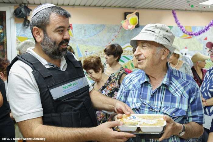 A charity worker distributes food to the elderly at Ofakim Shelter in Israel in October 2023. 