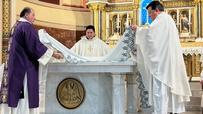 Father Michele Vricella (center) and Deacon Michael Chirichella (left) help Monsignor Joseph Grimaldi, vicar general of the Diocese of Brooklyn, to strip and prepare the altar to be blessed at Annunciation of the Blessed Virgin Mary Church in Brooklyn, New York, on Nov. 4, 2023.