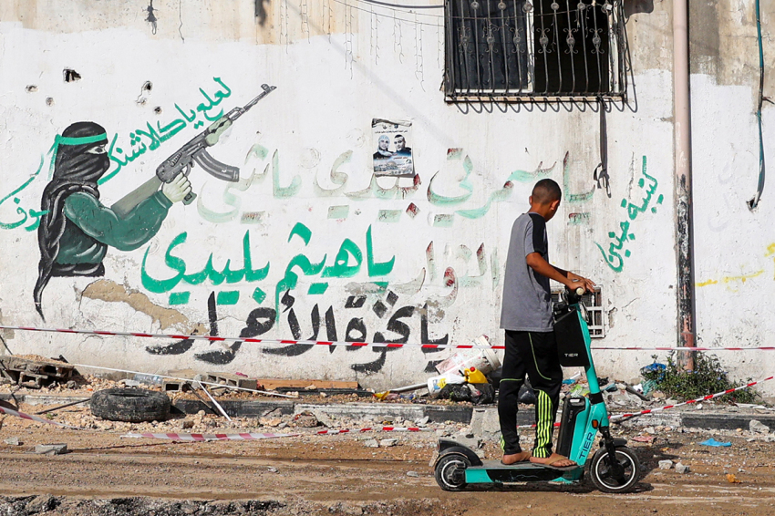 A Palestinian youth rides his scooter in the Tulkarem refugee camp in the West Bank on November 7, 2023, following an overnight raid by Israeli troops amid ongoing battles between Israel and the militant group Hamas.