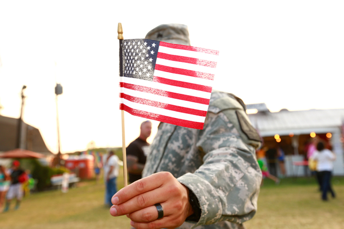 U.S. veteran holding American flag. 