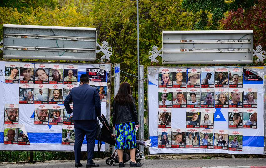 A couple with children looks at portraits of Israeli hostages held in Gaza since the October 7 attacks by Hamas terrorists, on billboards in Jerusalem as a truce between Israel and Hamas entered its second day on November 25, 2023. Hamas is expected to release another 14 Israeli hostages in exchange for 42 Palestinian prisoners on November 25, as part of a four-day truce in their seven-week war.