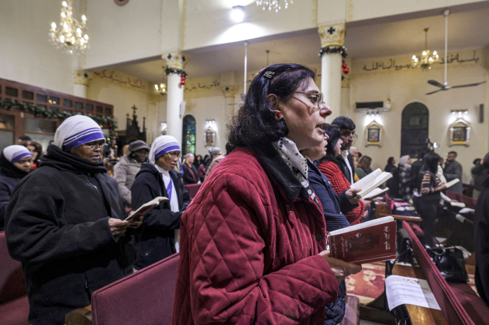 Worshippers chant hymns during Christmas Eve service at the Roman Catholic Church of the Holy Family in Gaza City on December 24, 2022. 