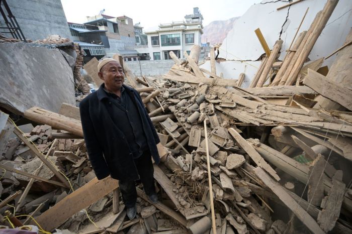 A man inspects a damaged building after an earthquake at Dahejia in Jishishan County in northwest China's Gansu province on December 20, 2023. Survivors of China's deadliest earthquake in years huddled in aid tents on Wednesday after overnight temperatures plunged well below zero, with the death toll rising to 131.