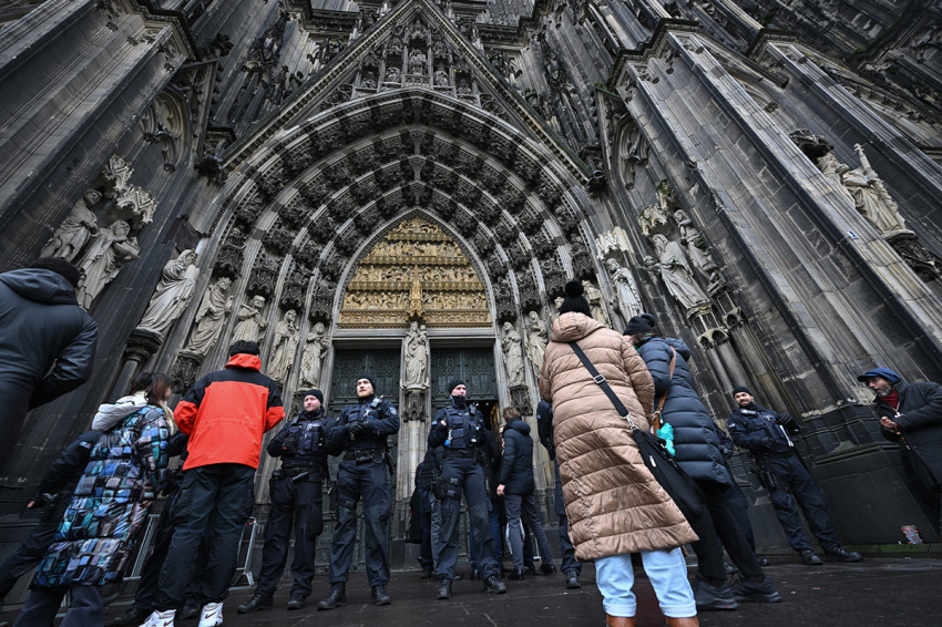 People stand outside the Cologne Cathedral as police controls on December 24, 2023, in Cologne. German police announced on December 23, 2023, evening they were searching the cathedral in the western city of Cologne with sniffer dogs following a 