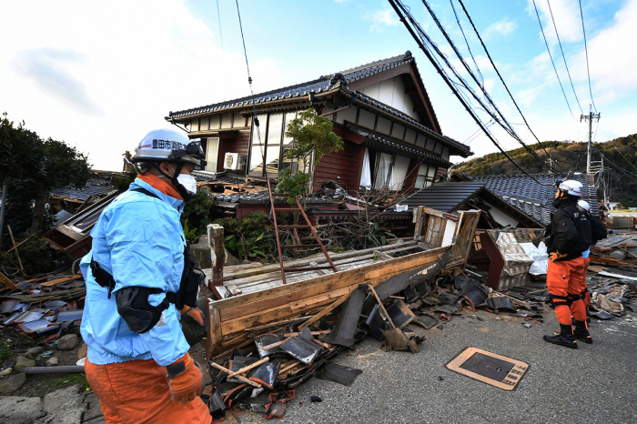 Firefighters inspect collapsed wooden houses in Wajima, Ishikawa, prefecture on January 2, 2024, a day after a major 7.5 magnitude earthquake struck the Noto region in Ishikawa prefecture in the afternoon. Japanese rescuers battled against the clock and powerful aftershocks on January 2 to find survivors of a major earthquake that struck on New Year's Day, reportedly killing more than 50 people and leaving a trail of destruction. 