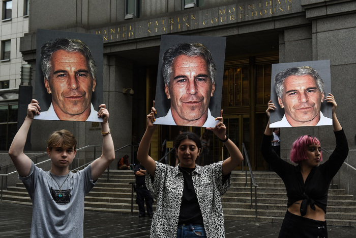 A protest group called 'Hot Mess' hold up signs of Jeffrey Epstein in front of the Federal courthouse on July 8, 2019, in New York City. According to reports, Epstein will be charged with one count of sex trafficking of minors and one count of conspiracy to engage in sex trafficking of minors.