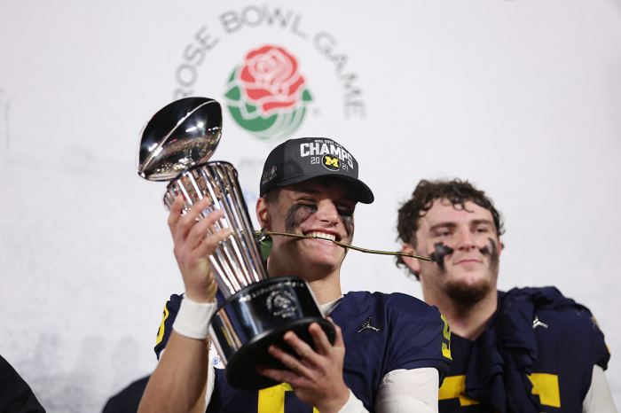 J.J. McCarthy #9 of the Michigan Wolverines celebrates with The Leishman Trophy after beating the Alabama Crimson Tide 27-20 in overtime to win the CFP Semifinal Rose Bowl Game at Rose Bowl Stadium on January 01, 2024, in Pasadena, California. 