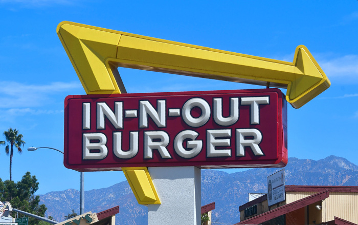 The signs points to an In-N-Out Burger restaurant in Alhambra, California, on August 30, 2018. 