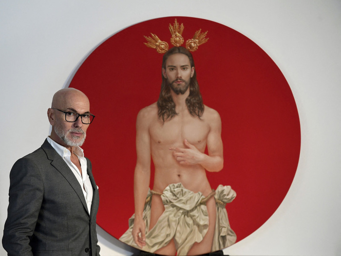 Spanish artist Salustiano Garcia poses for a photograph next to the Christ he painted for the official poster of 'Semana Santa de Sevilla 2024' (Sevilla's Holy Week celebrations) in his studio in Bormujos, near Sevilla on January 29, 2024. The official poster chosen for the Holy Week festivities in Seville (south) arouses the anger of ultra-conservatives, who demand its withdrawal, deeming it 'offensive' for Catholics. 