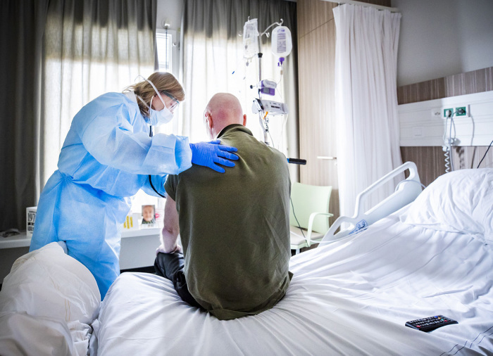 An attending physician listens to the breathing of a patient who is recovering after admission to an intensive care unit (ICU) in the coronavirus (COVID-19) patient nursing department of The HMC Westeinde Hospital in The Hague on April 4, 2020. 