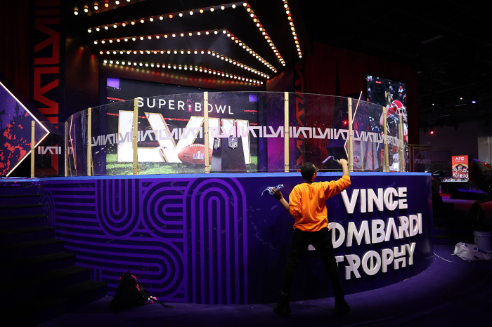 A worker paints final touches on a display in the NFL Super Bowl Experience ahead of Super Bowl LVIII on February 06, 2024, in Las Vegas, Nevada. 