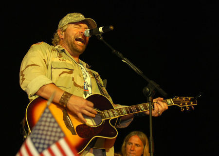 Toby Keith performs for service members at the Camp Liberty Post Exchange Stage, April 26, 2008, during his sixth United Services Organizations tour.