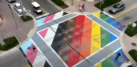 An aerial image shows a variety of tire marks and 'burnouts' from cars driving over the progress pride intersection in Delray Beach, Florida.