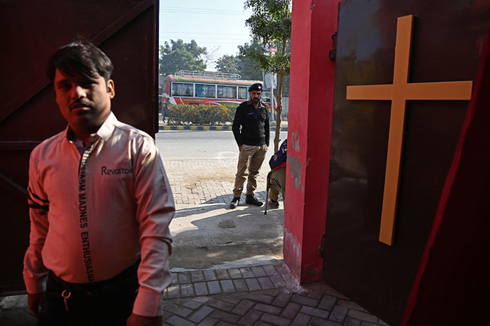 Police officers stand guard outside the restored Presbyterian Church in Jaranwala on Christmas Day, December 25, 2023. 