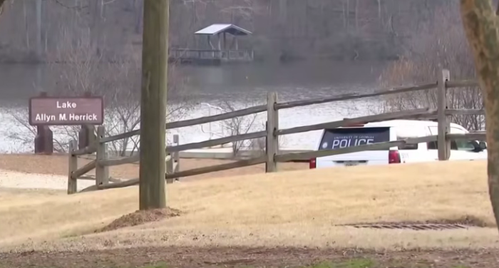 A police vehicle is stopped alongside a lake on the University of Georgia campus following the murder of nursing student Laken Riley on Feb. 22, 2024. 