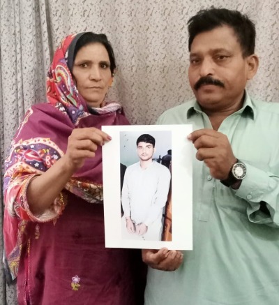 The parents of Noman Masih hold a photograph of their imprisoned son. 