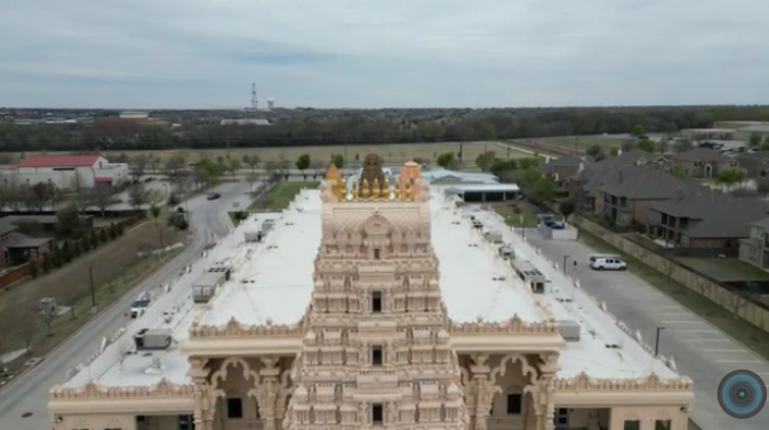 A screenshot of video showing the Karya Siddhi Hanuman Temple from the east in Frisco, Texas. The Rejoice Lutheran Church can be seen in the upper left corner.