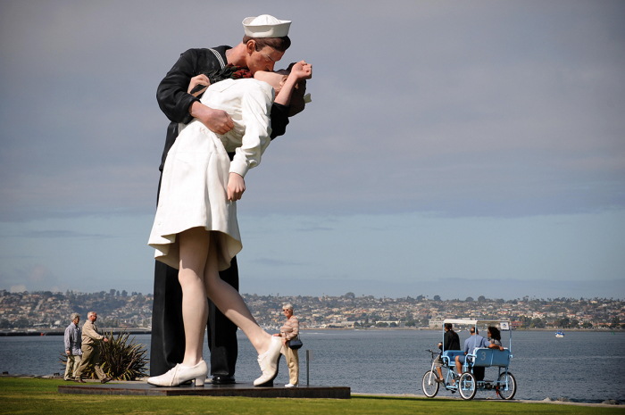 People walk near a sculpture by J. Seward Johnson on March 4, 2009, in San Diego, California. The 25-foot high sculpture is based on the famous photo by German American photographer Alfred Eisenstaedt, of a sailor kissing a nurse in Times Square, New York City, while celebrating the declaration of victory at the end of World War II. on August 14, 1945, that was originally published in Life magazine.