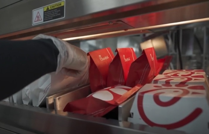 A Chick-fil-A employee places sandwiches on a heated rack in New York City. 