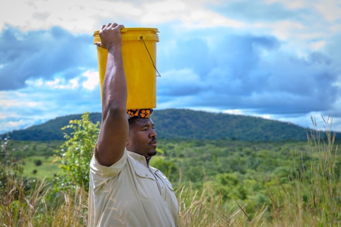 Kelvin Beachum, a 13-year NFL veteran who plays for the Arizona Cardinals, carrying water in Zambia during a World Vision trip to see water wells built with his donation. 