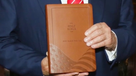 President Donald Trump holds up a