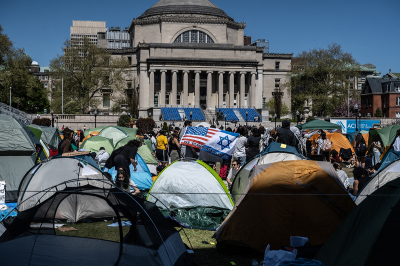 Columbia University students participate in an ongoing pro-Palestinian encampment on their campus with a pro-Israel student holding an Israeli flag on April 23, 2024, in New York City. In a growing number of college campuses throughout the country, student protesters are setting up tent encampments on school grounds to call for a ceasefire in Gaza and for their schools to divest from Israeli companies.