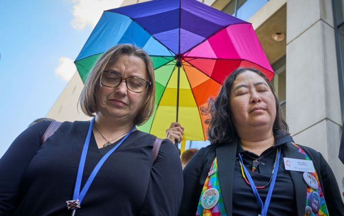Amanda Mountain and Bridget Cabrera pray outside the Charlotte Convention Center on May 2 following a decision by the 2024 United Methodist General Conference to approve a revision of the denomination's Social Principles. The newly approved document eliminates a statement that the practice of homosexuality was incompatible with church teaching.