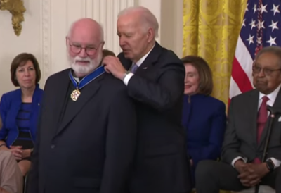 President Joe Biden places the Presidential Medal of Freedom around the neck of Fr. Gregory Boyle, a Jesuit priest who founded the gang-rehabilitation and re-entry program Homeboy Industries, in a ceremony at the White House, May 3, 2024. 