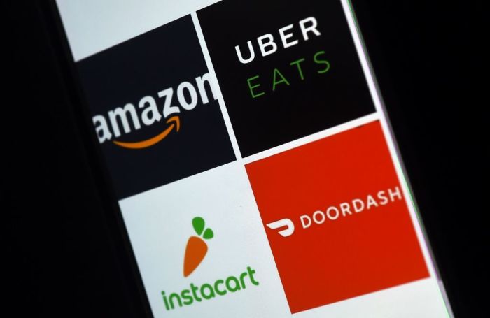 This illustration picture shows delivery applications logos from Amazon, Uber Eats, Instacart and Doordash displayed on a smartphone on April 10, 2020, in Arlington, Virginia - More and more people use the delivery apps as they are sheltering at home,avoiding going out as much as possible due to the coronavirus outbreak.