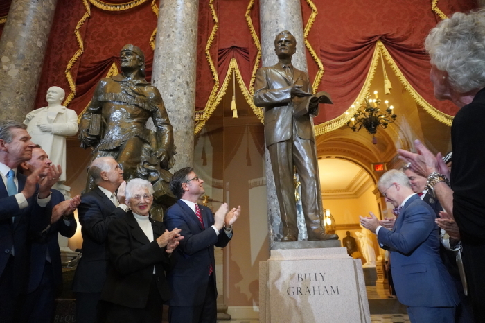 Attendees, including Speaker of the House Mike Johnson, R-La., clap their hands in applause during the unveiling of the Billy Graham statue at the U.S. Capitol on May 16, 2024. 