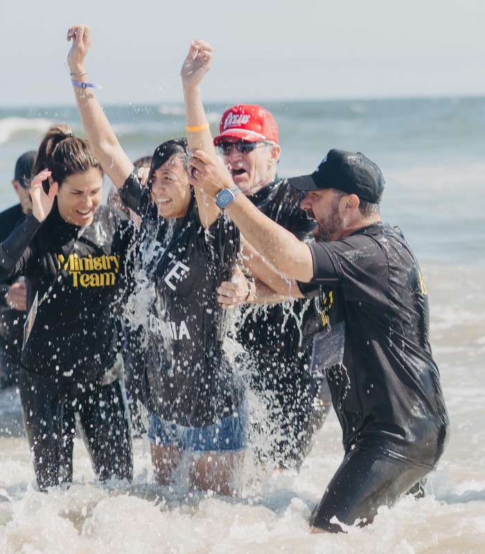 A woman reacts after getting baptized during Baptize California at Huntington Beach, Calif., on May 19, 2024.