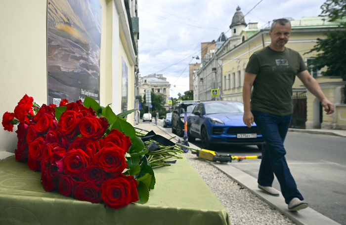 A man walks past the flowers laying in front of the representative office of Dagestan in Moscow on June 24, 2024, following terrorist attacks in Dagestan. Attacks on churches and synagogues in Russia's Dagestan region killed 15 police officers and four civilians, officials said on June 24, 2024, stoking fears over Islamist violence in the historically restive North Caucasus. The attacks come just three months after Islamic State (IS) group fighters killed more than 140 in a Moscow concert hall, the deadliest attack on Russia for almost 20 years. 