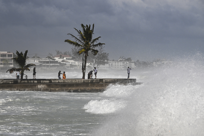 People visit a pier during a high tide after the passage of Hurricane Beryl in Oistins near Bridgetown, Barbados, on July 1, 2024. Hurricane Beryl brought devastating winds and heavy rain to several Caribbean islands on July 1, 2024, as the earliest-ever Category 4 storm churned westward. 
