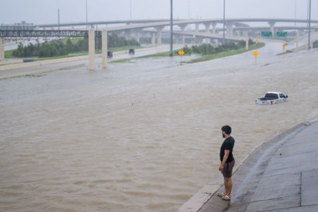 A person looks out towards the flooded interstate after Hurricane Beryl swept through the area on July 08, 2024 in Houston, Texas.