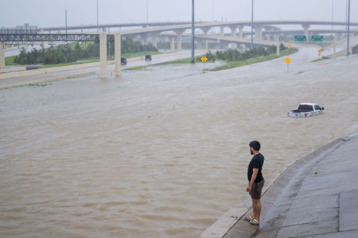 A person looks out towards the flooded interstate after Hurricane Beryl swept through the area on July 08, 2024 in Houston, Texas. 