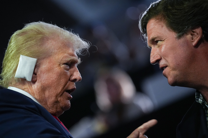 Republican presidential candidate, former U.S. President Donald Trump, greets Tucker Carlson on the first day of the Republican National Convention at the Fiserv Forum on July 15, 2024, in Milwaukee, Wisconsin. Delegates, politicians, and the Republican faithful are in Milwaukee for the annual convention, concluding with former President Donald Trump accepting his party's presidential nomination. The RNC takes place from July 15-18. 