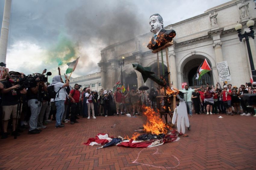 Protesters burn an American flag outside of Union Station following Israeli Prime Minister Benjamin Netanyahu's address during a joint session of congress, in Washington, D.C. on July 24, 2024.