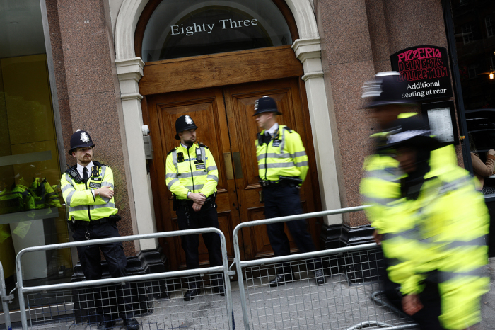 Police officers stand on duty outside the entrance to a building housing the headquarters of the Reform UK political party, during a 'Stop the Far-right' demonstration on a National Day of Protest, in London on August 10, 2024. Brexit activist Nigel Farage, whose anti-illegal immigration Reform UK party won 14 percent of the vote on the July 4 general election, has suggested the recent rioting stems from legitimate grievances about mass immigration, rather than simply far-right thuggery, and warned worse could be seen on the streets. 