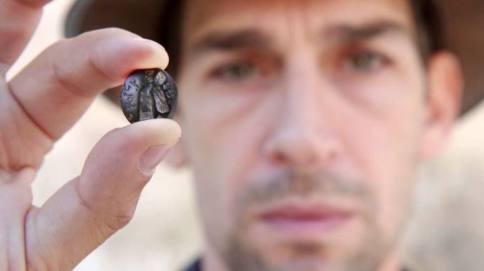 A man holds up a 2,700-year-old seal found in the City of David National Park in Jerusalem. 