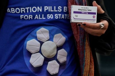 A pro-abortion rights activist holds a box of mifepristone during a rally in front of the US Supreme Court on March 26, 2024, in Washington, DC. 