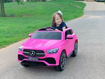 Melody, who was born with trisomy 18, driving her pink Mercedes toy car.