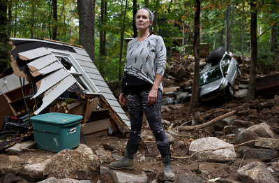 Liesl Steiner stands for a photo outside a destroyed garage of her flood damaged home in the aftermath of Hurricane Helene on Oct. 4, 2024, in Swannanoa, North Carolina. Steiner said a powerful mudslide carrying rocks and boulders tumbled down the mountainside and through part of her property. Many homes in the area were damaged by the mudslides. At least 227 people were killed in six states in the wake of the powerful hurricane which made landfall as a Category 4. It is now the deadliest U.S. mainland hurricane since Hurricane Katrina. 