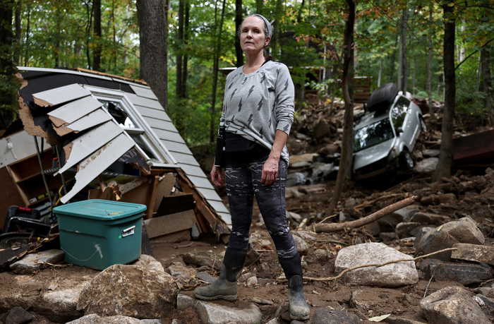 Liesl Steiner stands for a photo outside a destroyed garage of her flood damaged home in the aftermath of Hurricane Helene on Oct. 4, 2024, in Swannanoa, North Carolina. Steiner said a powerful mudslide carrying rocks and boulders tumbled down the mountainside and through part of her property. Many homes in the area were damaged by the mudslides. At least 225 people were killed in six states in the wake of the powerful hurricane which made landfall as a Category 4. It is now the deadliest U.S. mainland hurricane since Hurricane Katrina. 